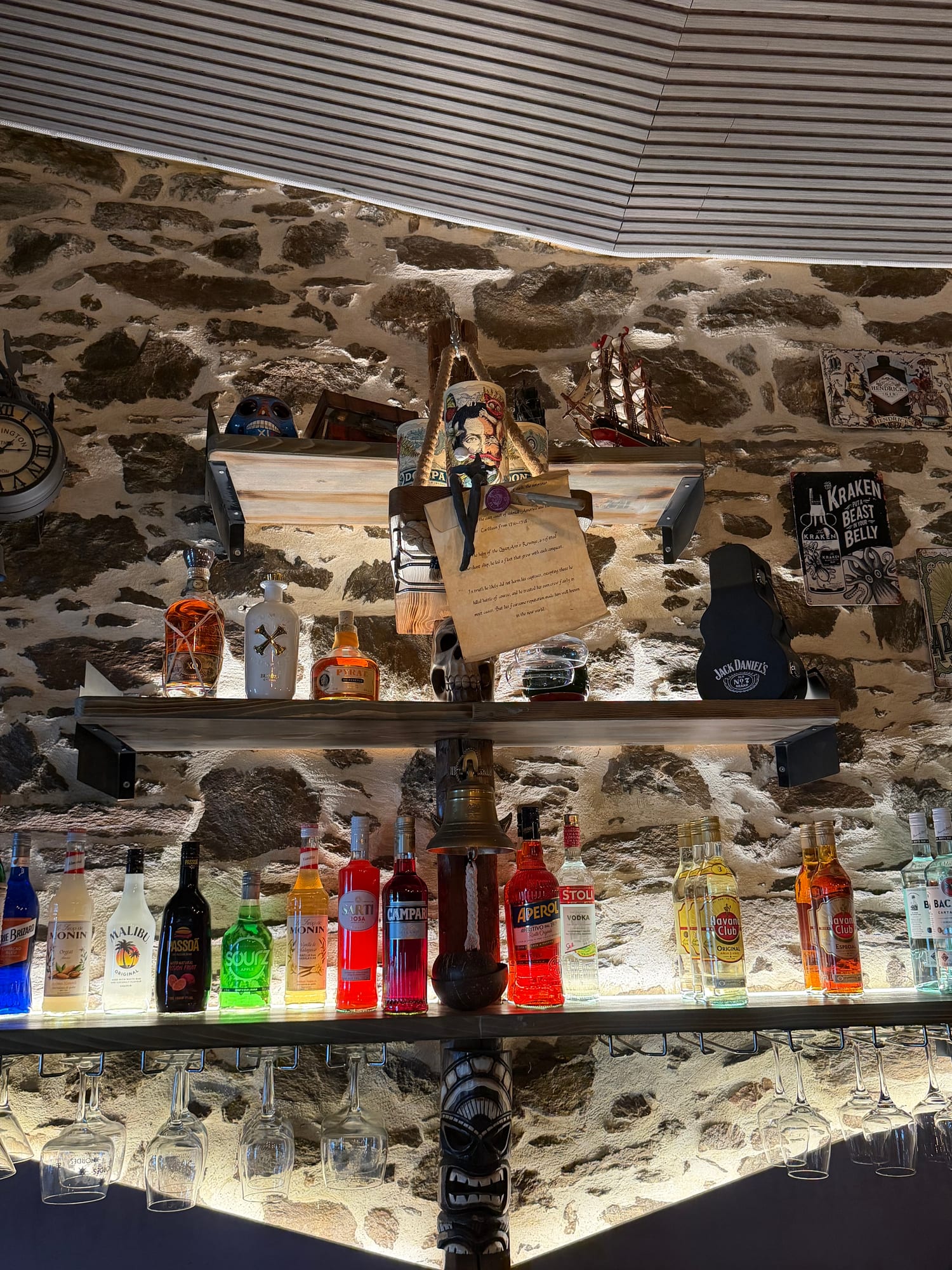 Bar shelf with a Kraken sign, model ship and rock memorabilia