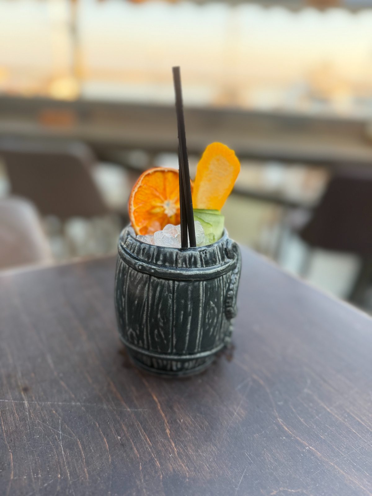 Barrel-shaped tiki mug cocktail with citrus garnish