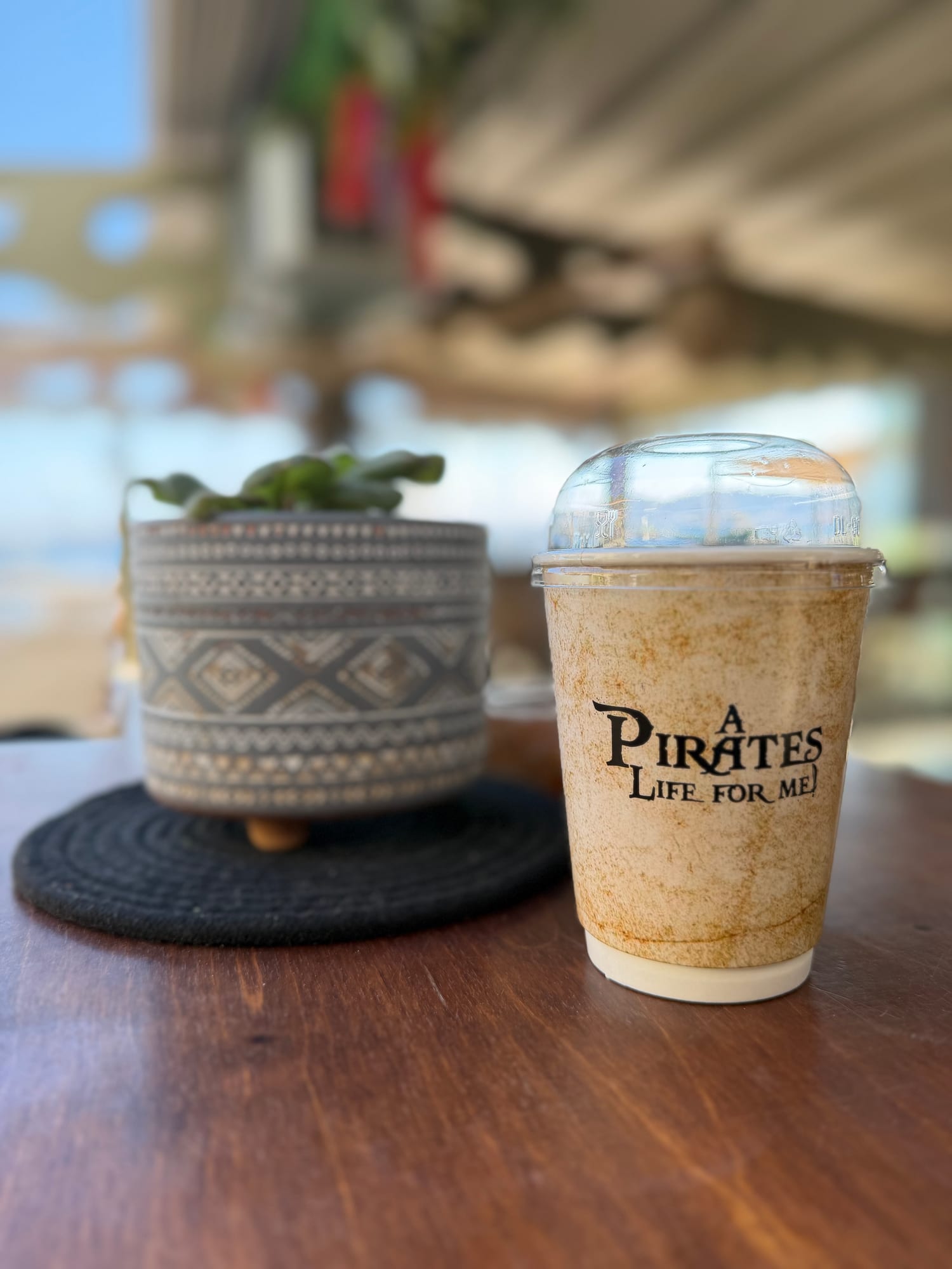 Black Pearl branded cup on a sunlit terrace table