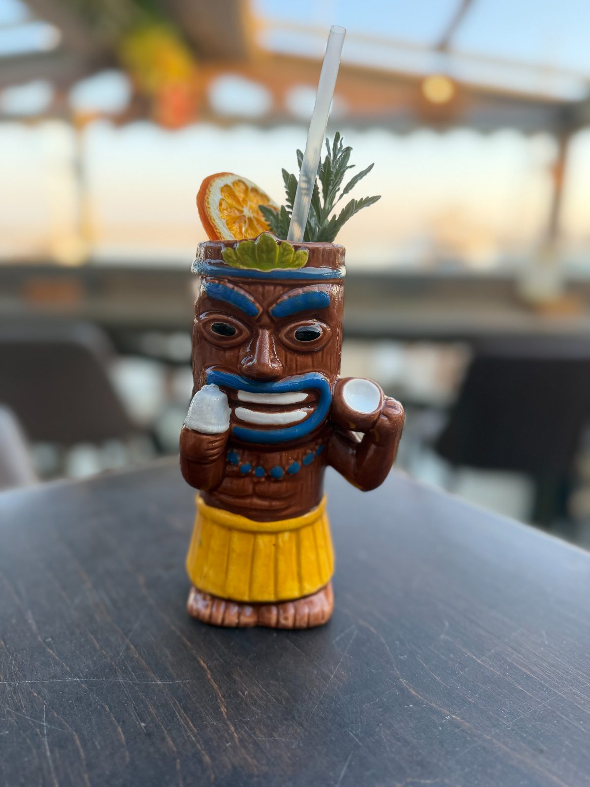 Hula-dancer tiki mug cocktail with citrus garnish